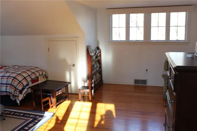 a bedroom with a bed and wooden floor