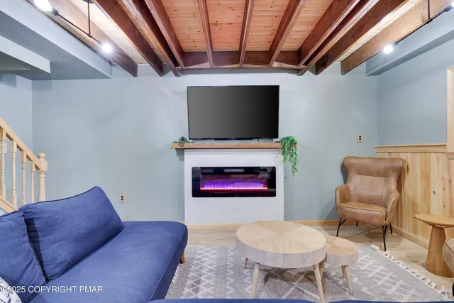 a living room with furniture a flat screen tv and a fireplace