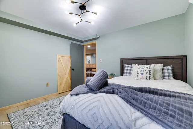 a bedroom with a large bed and a chandelier