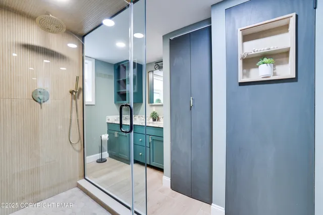 a bathroom with a glass shower door and a sink