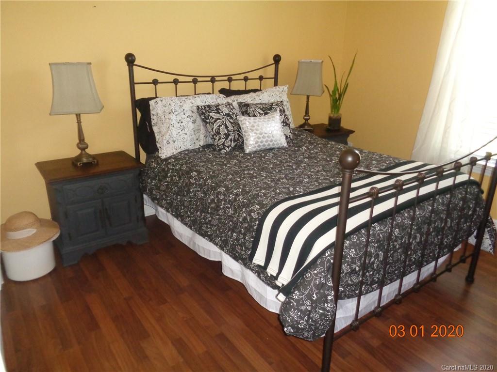 5422 Fish Road Marshville, NC 28103 - Photo 11 of 38 a bed sitting in a bedroom next to a lamp