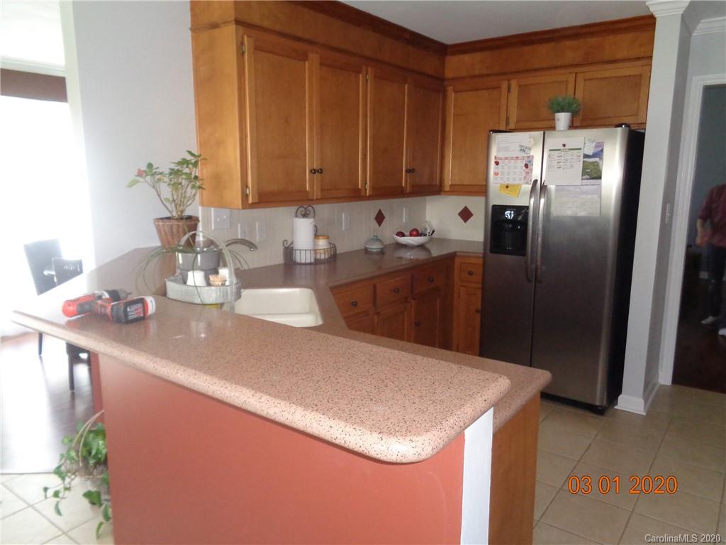 5422 Fish Road Marshville, NC 28103 - Photo 6 of 38 a kitchen with stainless steel appliances granite countertop a refrigerator a sink a stove with wooden cabinets