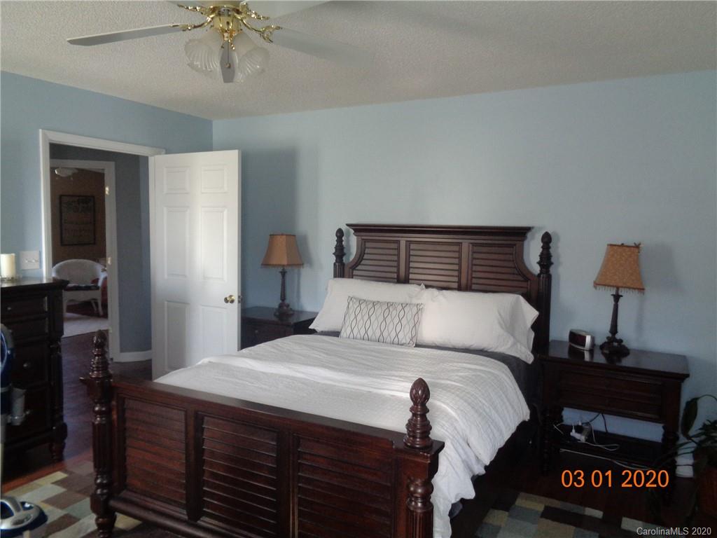 5422 Fish Road Marshville, NC 28103 - Photo 10 of 38 a bedroom with a bed and a chandelier