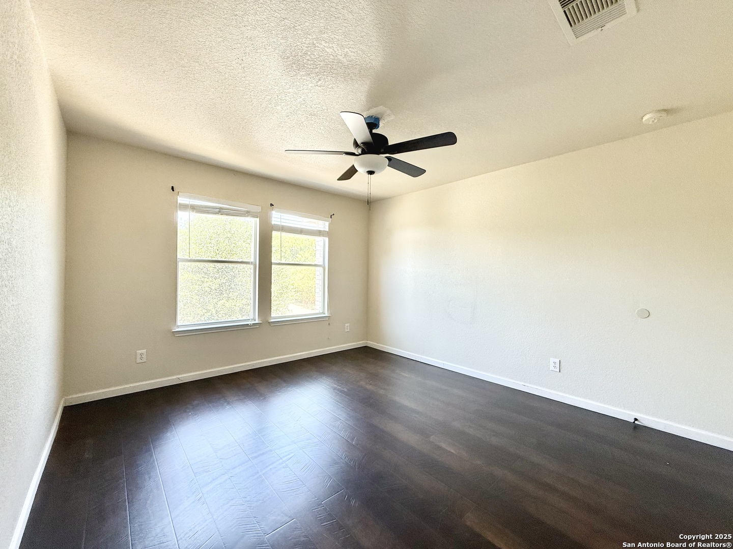 6118 Kensinger Pass Converse, TX 78109 - Photo 18 of 30 an empty room with wooden floor and chandelier fan
