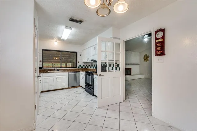 a kitchen with cabinets and chairs