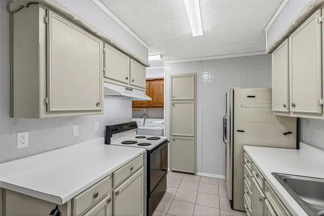 a kitchen with stainless steel appliances a refrigerator sink and cabinets