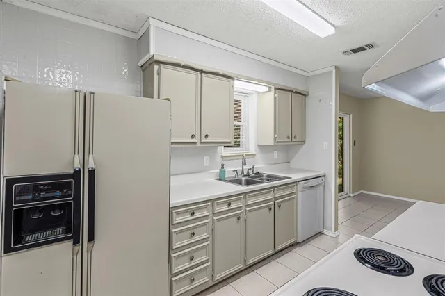 a kitchen with a sink a refrigerator and cabinets
