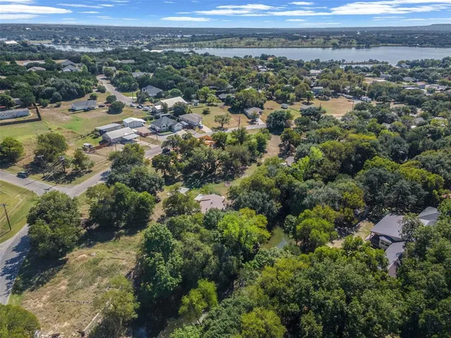 an aerial view of residential houses with outdoor space and trees