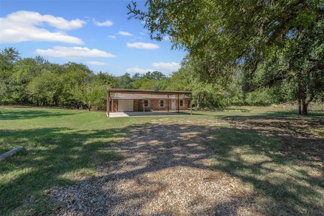 an aerial view of residential houses with outdoor space and trees