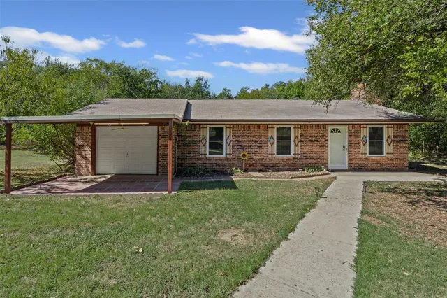 a front view of a house with a garden and yard