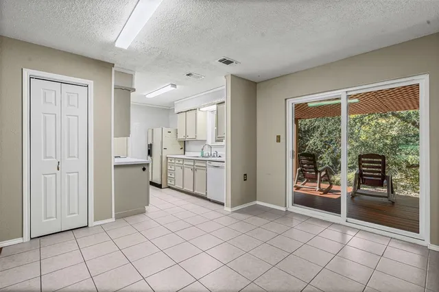 a open kitchen with white cabinets and white appliances