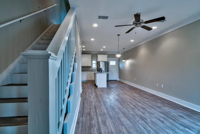 a view of a hallway with wooden floor and staircase