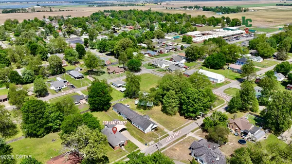 an aerial view of residential house with outdoor space and trees all around