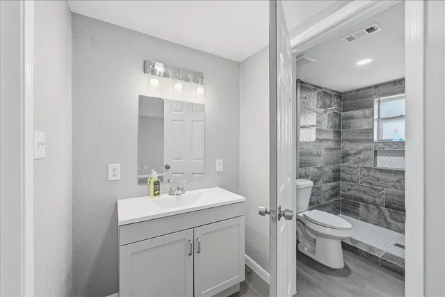 a bathroom with a sink a toilet and shower