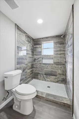 a bathroom with a toilet and a shower