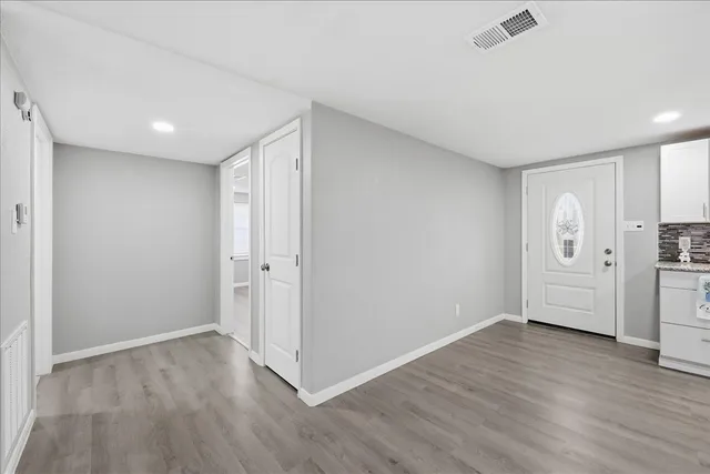 a view of empty room with wooden floor