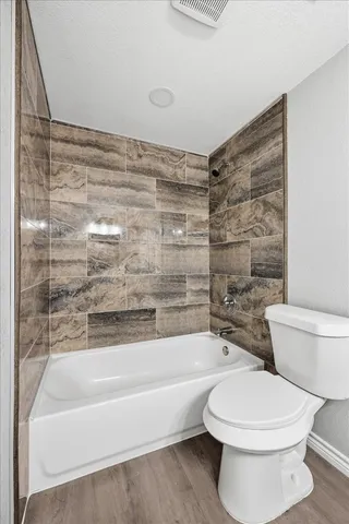 a bathroom with a toilet and a bath tub