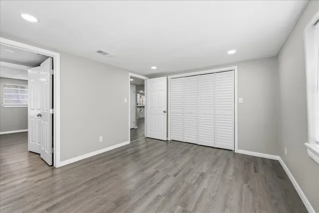 a view of an empty room with wooden floor