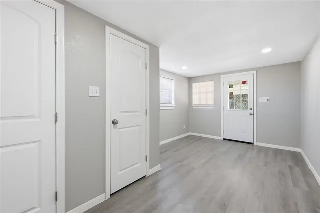 a view of an empty room with closet and wooden floor