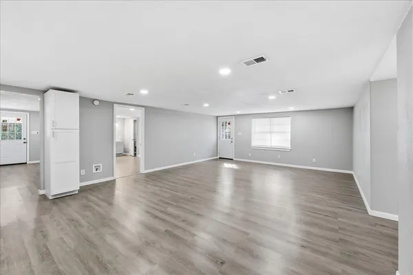a view of empty room with wooden floor