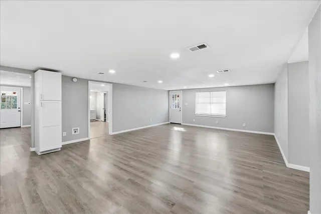a view of empty room with wooden floor