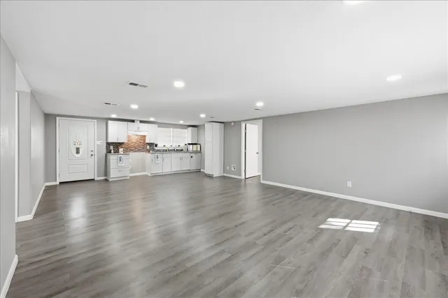a view of empty room with wooden floor