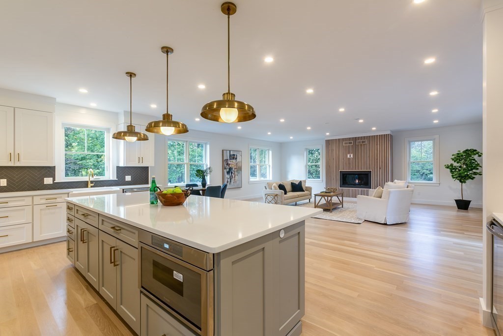 82 Border Road Needham, MA 02492 - Photo 2 of 8 a view of a kitchen with kitchen island a stove a sink a center island and a wooden floor