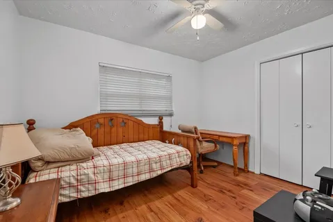a bedroom with a bed and wooden floor
