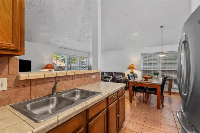 a kitchen with a sink dishwasher a stove and a dining table with garden view