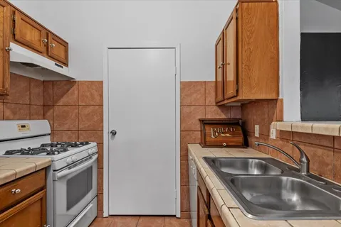 a kitchen with granite countertop a sink and a stove top oven