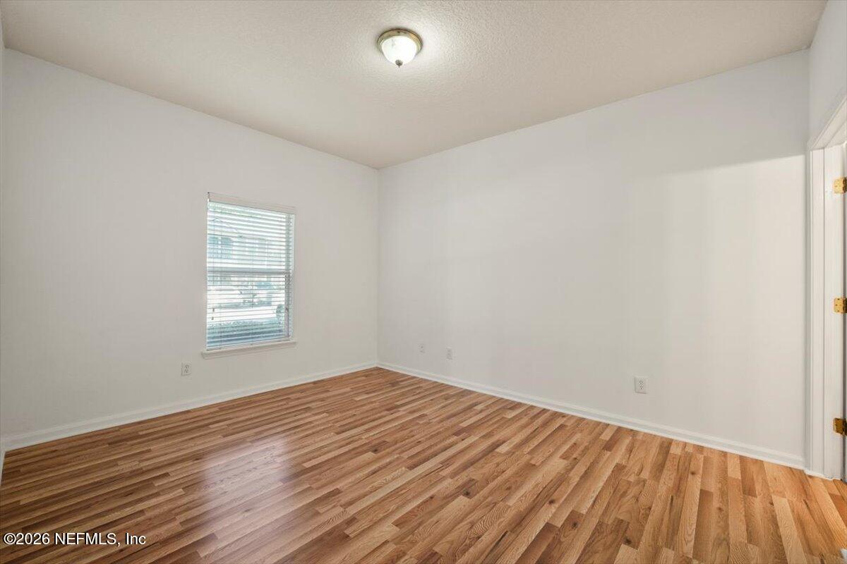 3641 Kirkpatrick Circle, Unit 141 Jacksonville, FL 32210 - Photo 11 of 25 an empty room with wooden floor and windows