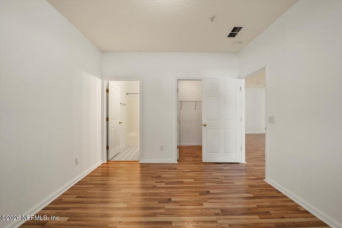 3641 Kirkpatrick Circle, Unit 141 Jacksonville, FL 32210 - Photo 12 of 25 a view of an empty room with wooden floor and a bathroom