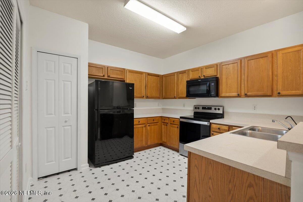 3641 Kirkpatrick Circle, Unit 141 Jacksonville, FL 32210 - Photo 5 of 25 a kitchen with a refrigerator a stove top oven a sink and dishwasher