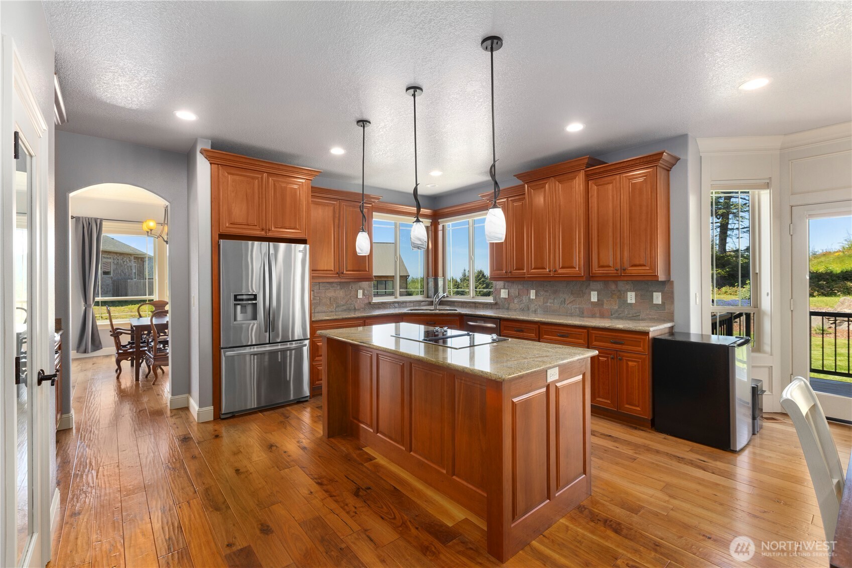 3015 Lighthouse Keepers Road Ilwaco, WA 98624 - Photo 12 of 40 a kitchen with stainless steel appliances granite countertop a refrigerator a sink a stove and oven