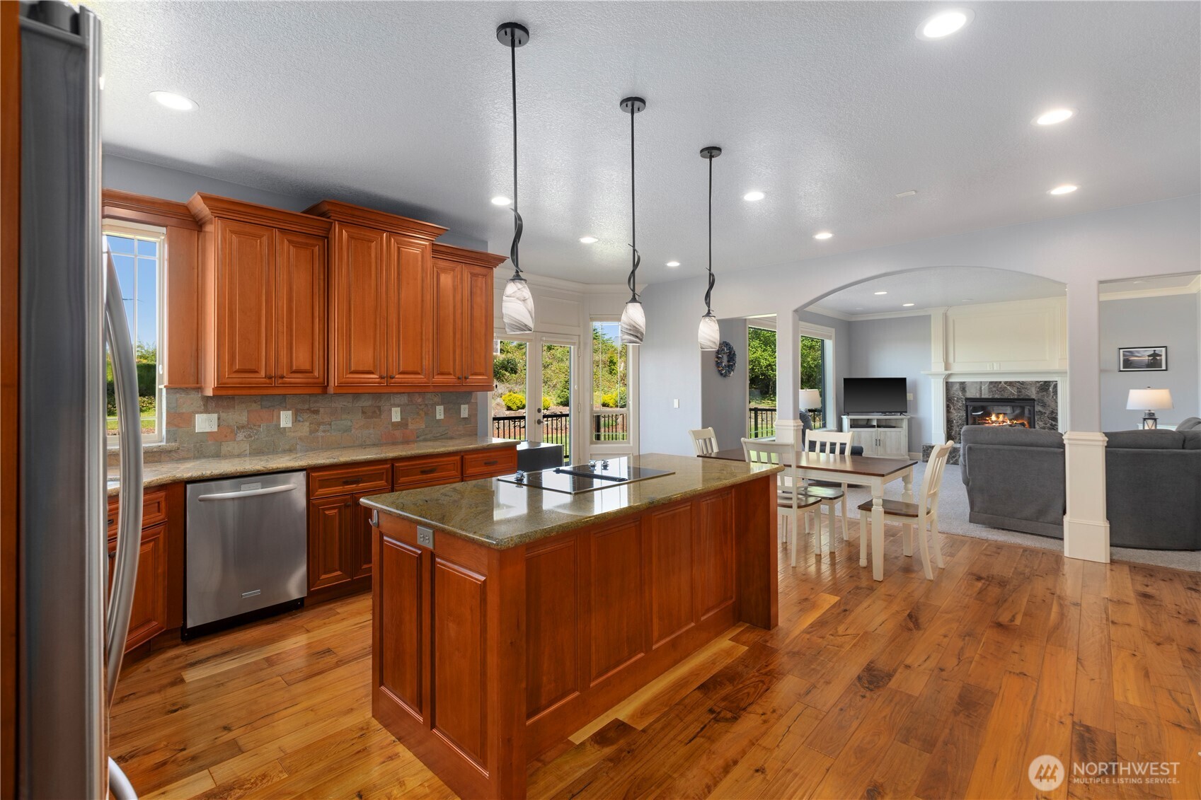 3015 Lighthouse Keepers Road Ilwaco, WA 98624 - Photo 10 of 40 a kitchen with stainless steel appliances granite countertop wooden cabinets a stove a sink a dining table and chairs