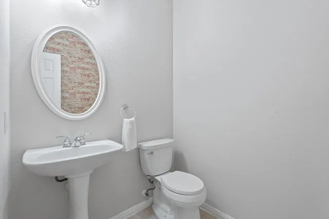 a bathroom with a toilet a sink and a mirror