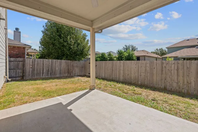 a view of a backyard with wooden fence