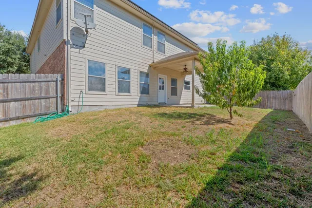 a backyard of a house with table and chairs