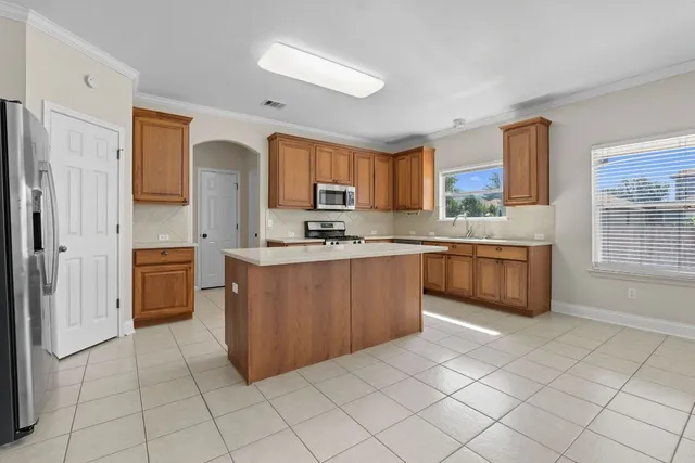 a kitchen with stainless steel appliances a sink cabinets and a window