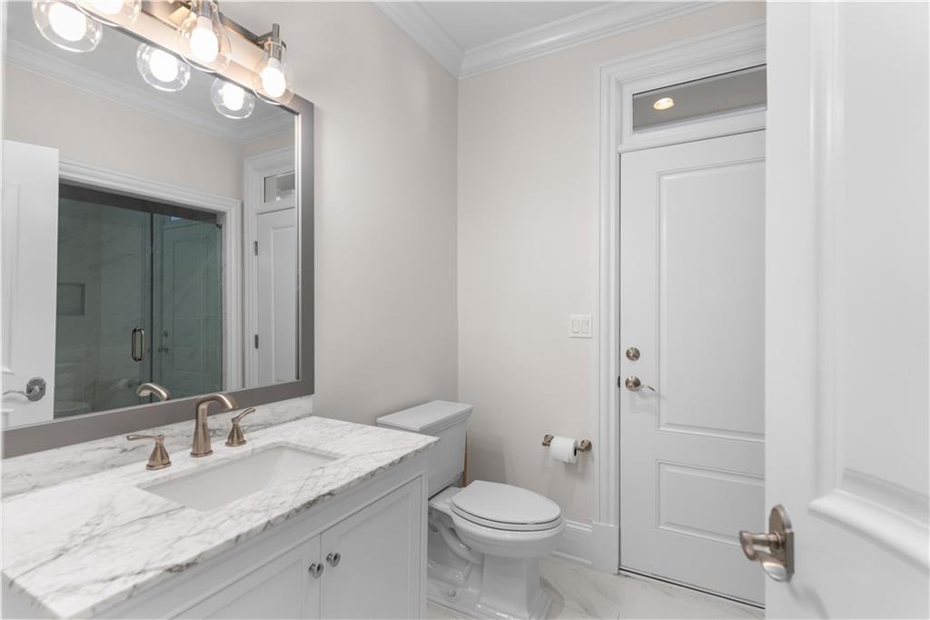 1070 Prosperity Point Greensboro, GA 30642 - Photo 31 of 38 a bathroom with a granite countertop sink toilet and shower
