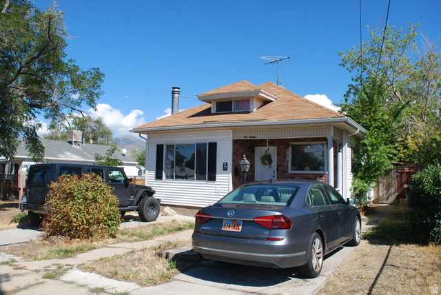 116 North 3rd Street Tooele, UT 84074 - Photo 45 of 45 White siding exterior with brick accents, multi-pane windows, and a dormer