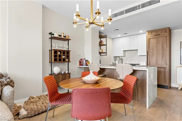 a dining room with furniture and a chandelier fan