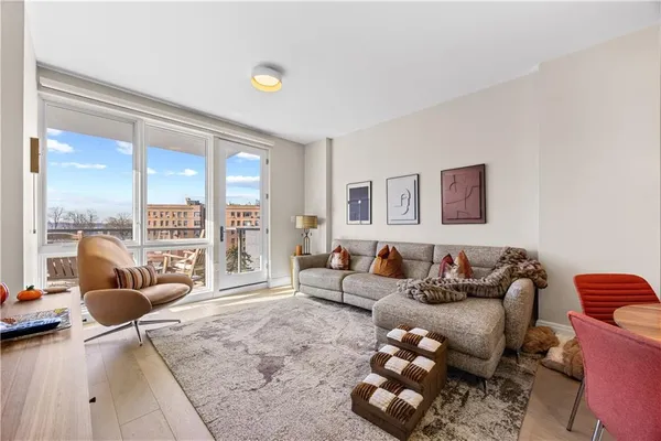 a living room with furniture a rug and a window
