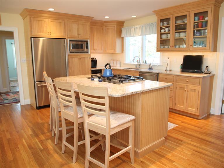 69 Goodview Way Barnstable, MA 02630 - Photo 4 of 17 a kitchen with stainless steel appliances granite countertop a table chairs sink refrigerator and microwave