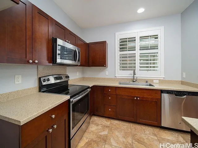 a kitchen with stainless steel appliances granite countertop a stove a sink and a microwave
