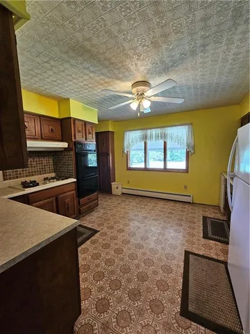 a open kitchen with stainless steel appliances granite countertop a stove a sink and a microwave