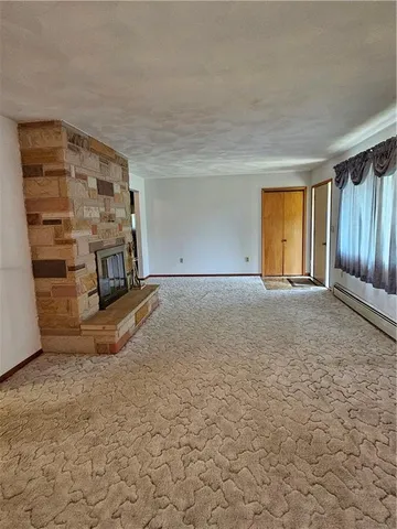 a view of an empty room with a fireplace and a window