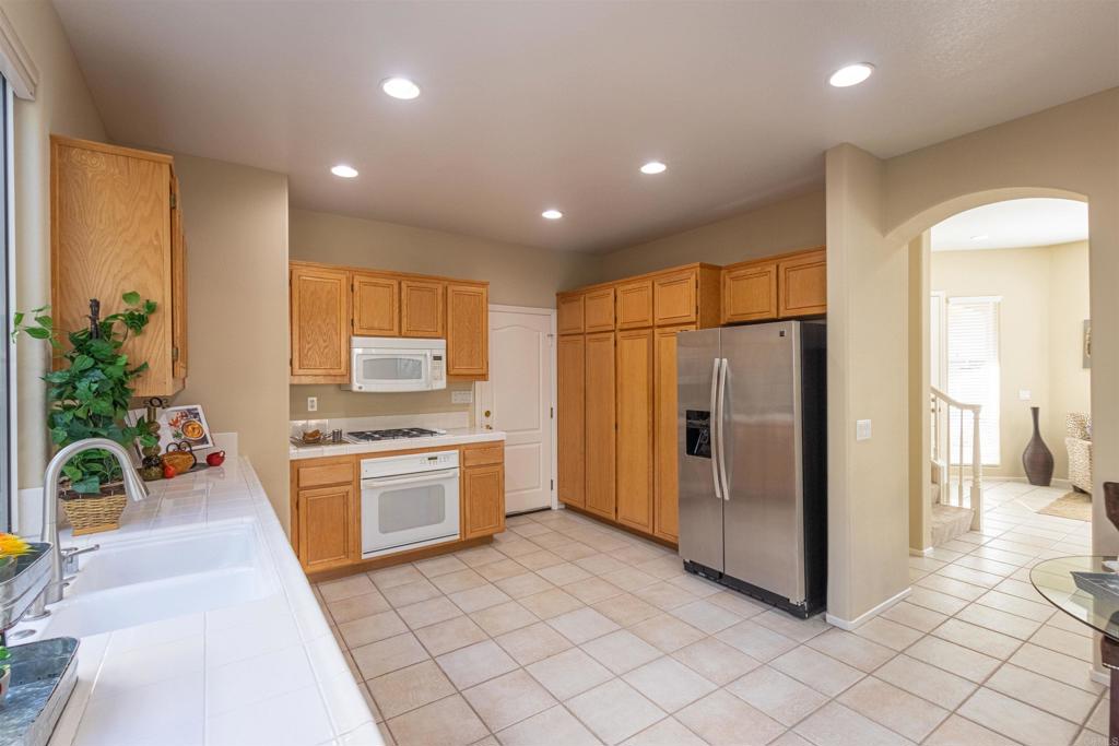 7189 Tanager Drive Carlsbad, CA 92011 - Photo 11 of 31 a kitchen with stainless steel appliances granite countertop a refrigerator and a sink