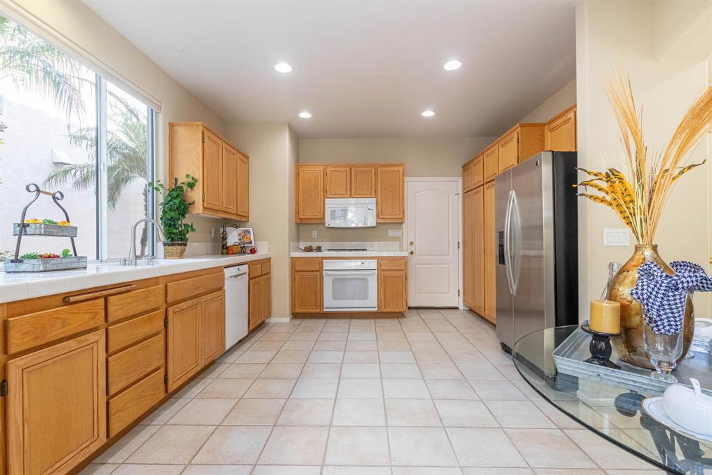 7189 Tanager Drive Carlsbad, CA 92011 - Photo 12 of 31 a kitchen with a sink refrigerator and cabinets