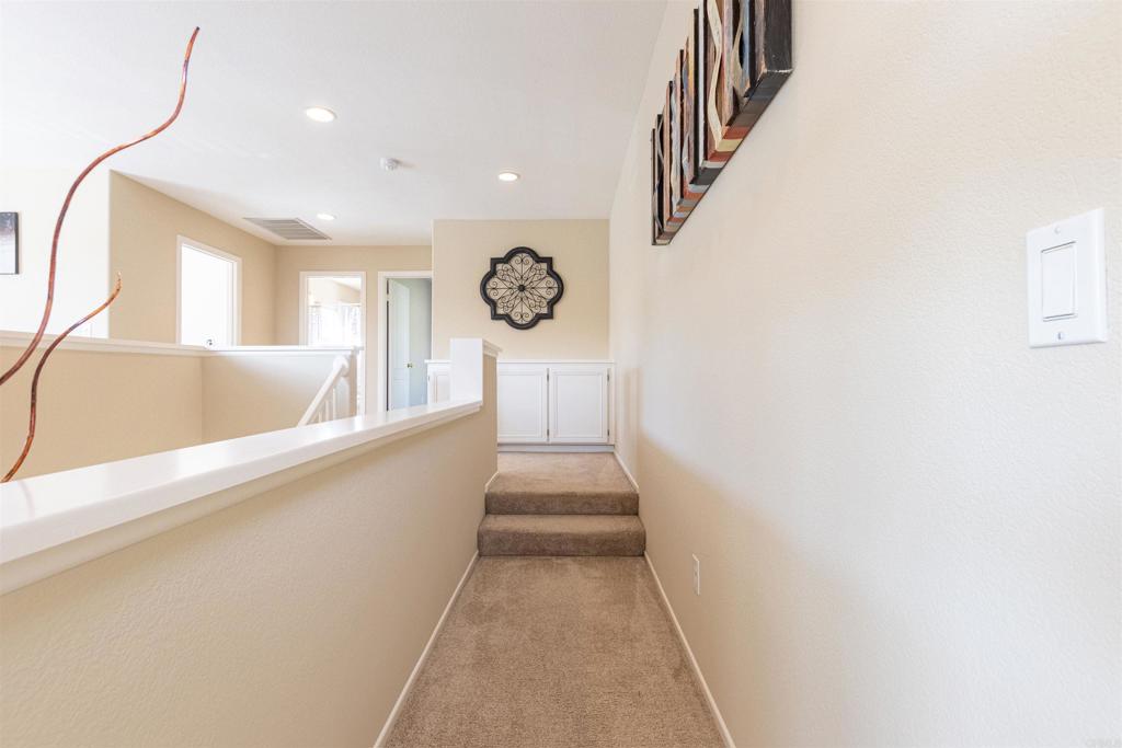 7189 Tanager Drive Carlsbad, CA 92011 - Photo 18 of 31 a hallway with stairs and wooden floor